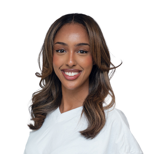 Smiling woman with wavy brown hair wearing a white shirt, facing the camera against a white background.