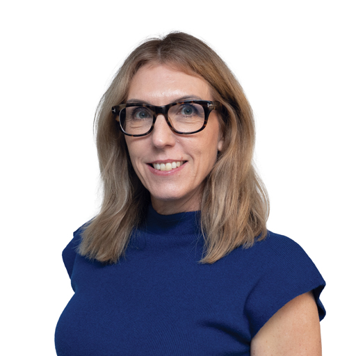 Smiling woman with shoulder-length blonde hair and black glasses wearing a blue top, against a white background.